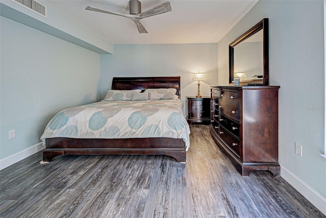 bedroom featuring ceiling fan, wood finished floors, visible vents, and baseboards