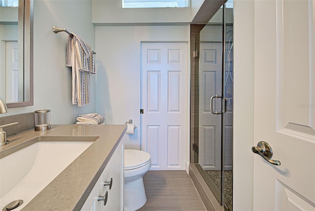 full bathroom with a stall shower, vanity, and toilet