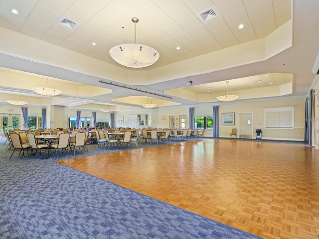 workout area with a raised ceiling, visible vents, and recessed lighting