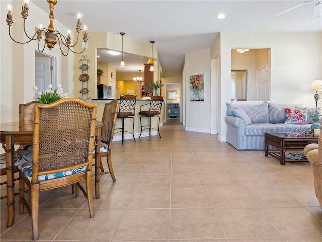 dining room featuring baseboards, light tile patterned flooring, and an inviting chandelier