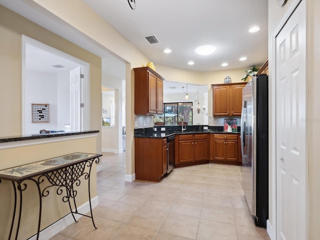 kitchen with light tile patterned floors, appliances with stainless steel finishes, brown cabinetry, and visible vents