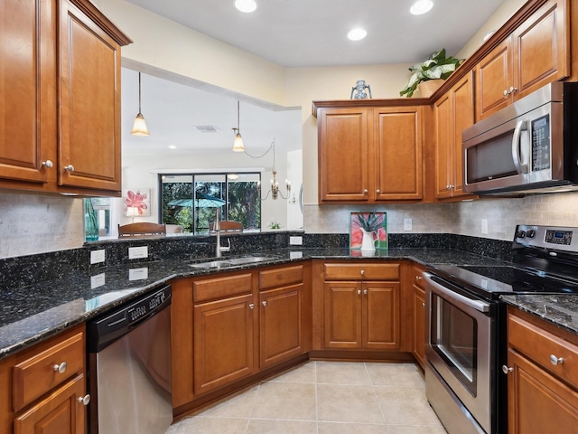 kitchen featuring tasteful backsplash, appliances with stainless steel finishes, brown cabinets, and a sink