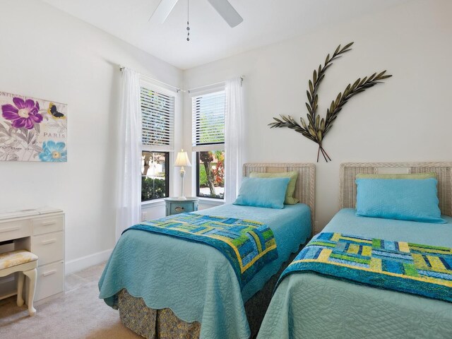 bedroom with light carpet, ceiling fan, and baseboards