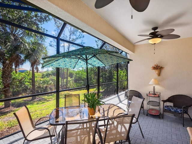 view of patio featuring a lanai, ceiling fan, and outdoor dining space