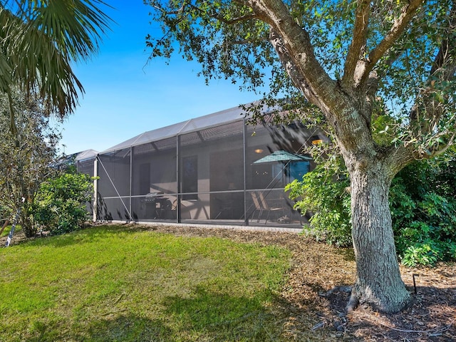 back of house with a yard and glass enclosure