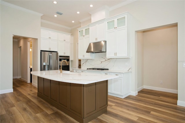 kitchen featuring stainless steel appliances, white cabinets, under cabinet range hood, and tasteful backsplash