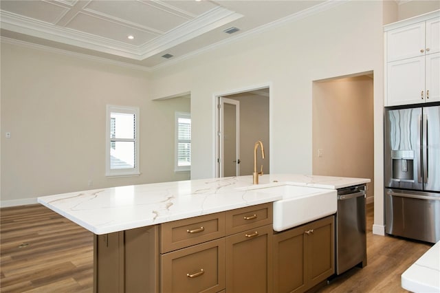 kitchen with light stone counters, dark wood-style floors, appliances with stainless steel finishes, white cabinetry, and a sink