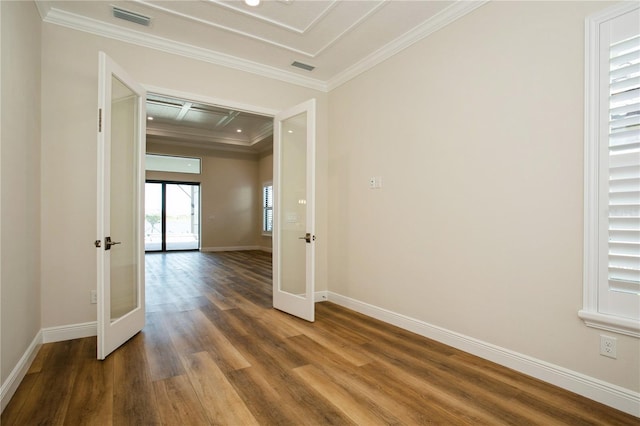 empty room with french doors, crown molding, visible vents, wood finished floors, and baseboards