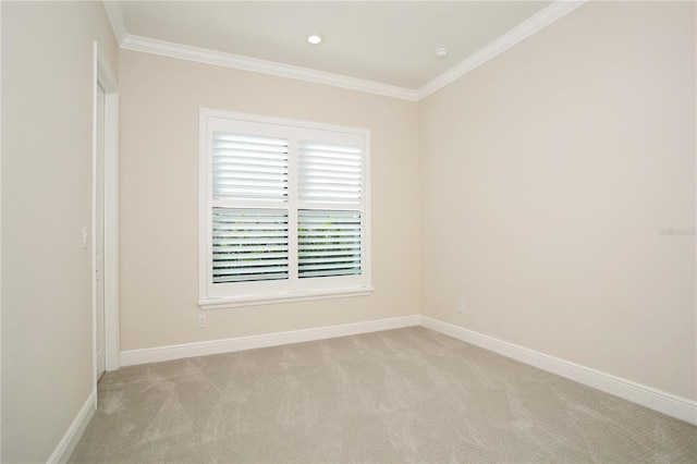 empty room with crown molding, baseboards, and light colored carpet