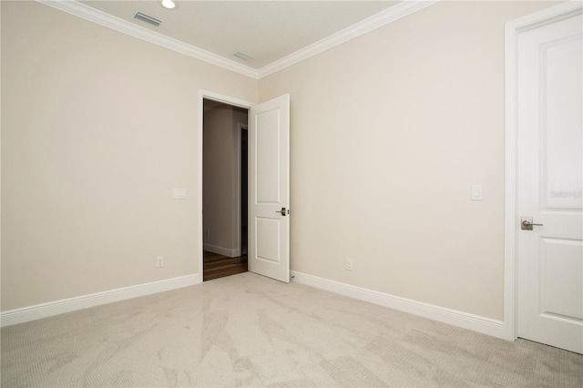 unfurnished room with light carpet, baseboards, visible vents, and ornamental molding