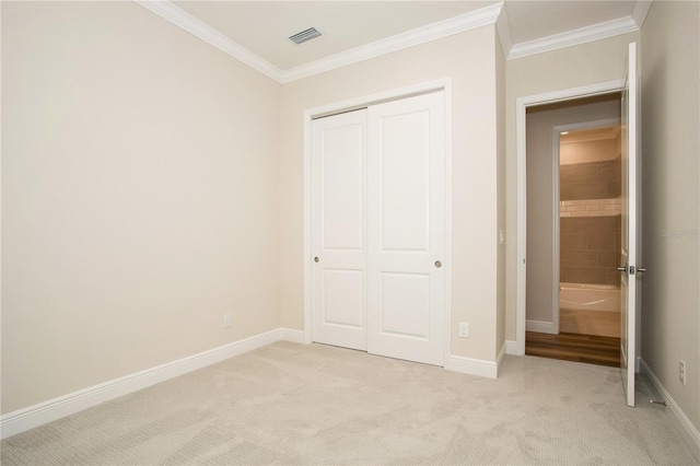 unfurnished bedroom with light carpet, a closet, visible vents, and crown molding