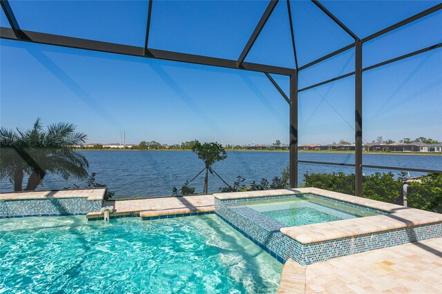 view of pool with a lanai, a water view, and a pool with connected hot tub