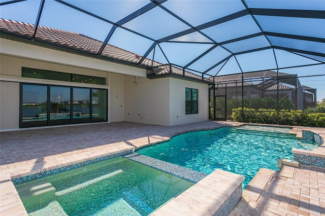 view of pool with a lanai, a patio area, and a pool with connected hot tub