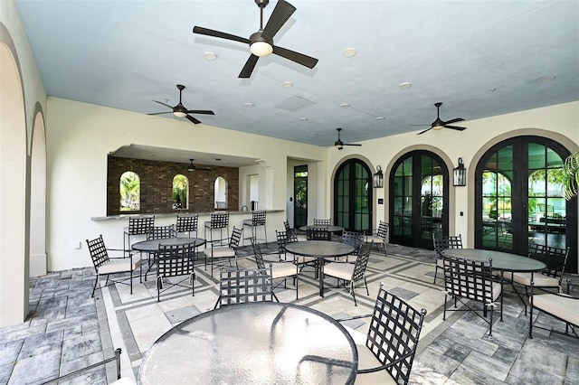 view of patio featuring a ceiling fan, outdoor dining space, and french doors