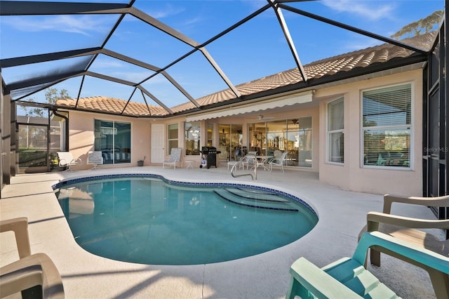 pool featuring glass enclosure, a patio, and grilling area