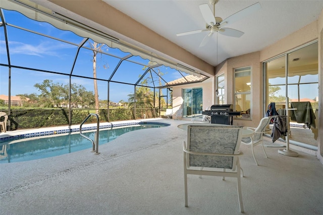 outdoor pool with a lanai, a patio area, and ceiling fan