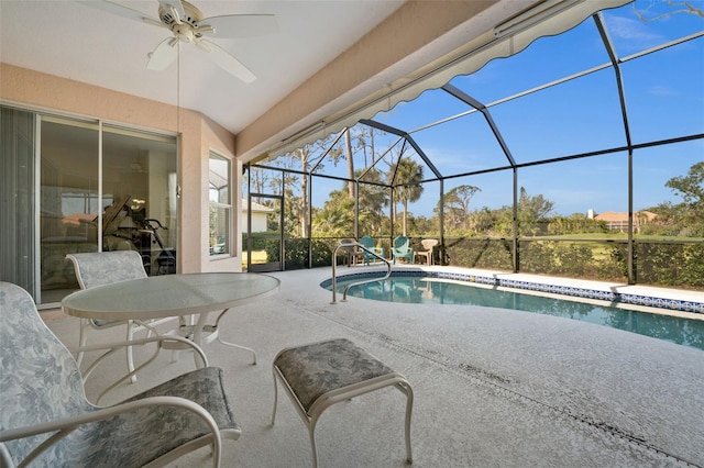 outdoor pool featuring a patio area, ceiling fan, and glass enclosure