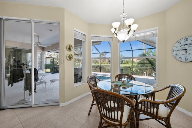 dining room featuring a sunroom, light tile patterned floors, baseboards, and ceiling fan with notable chandelier