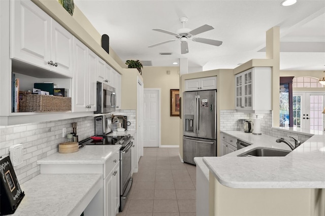 kitchen featuring light tile patterned floors, stainless steel appliances, a sink, visible vents, and glass insert cabinets