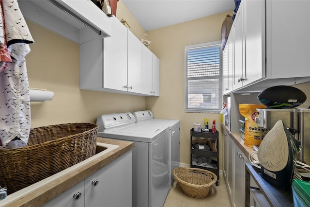 clothes washing area featuring baseboards, independent washer and dryer, cabinet space, and tile patterned floors