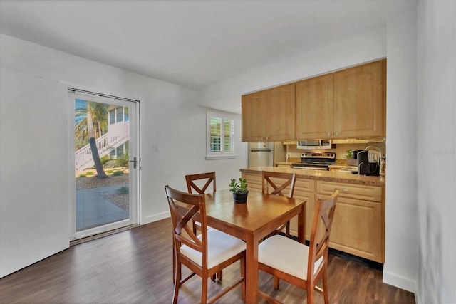 dining area featuring dark wood-type flooring and baseboards