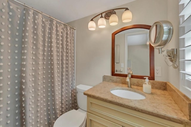 full bathroom with curtained shower, vanity, and toilet