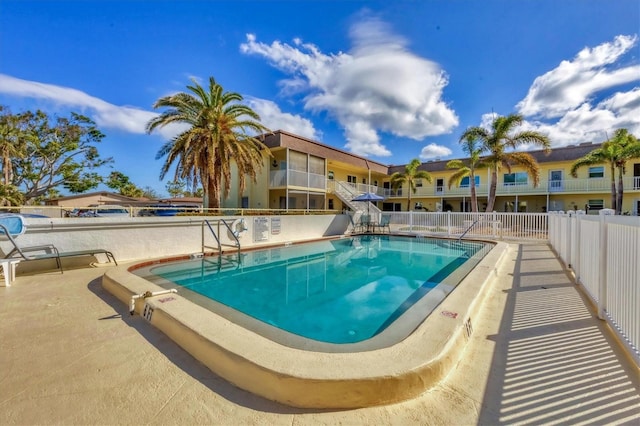 pool with a patio and fence