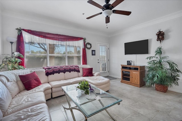 living area with ornamental molding, a ceiling fan, and baseboards