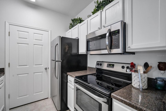 kitchen featuring appliances with stainless steel finishes, white cabinets, and light tile patterned flooring