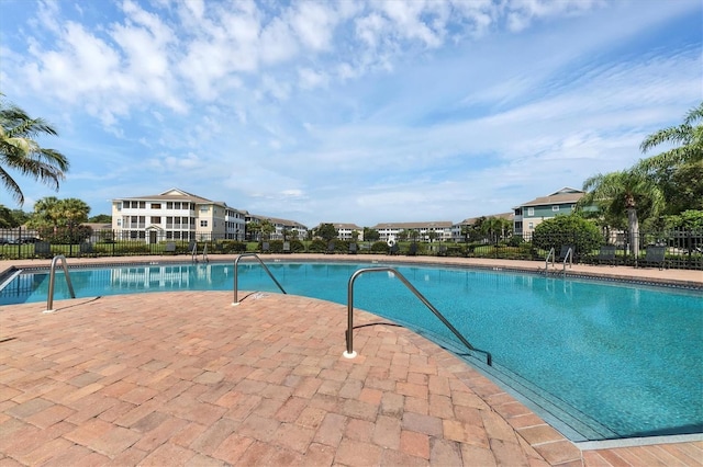 community pool featuring a patio area and fence