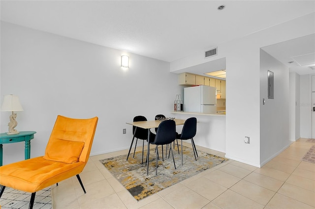 dining room featuring light tile patterned floors, baseboards, electric panel, and visible vents