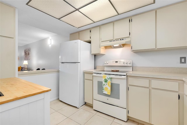 kitchen with white appliances, under cabinet range hood, cream cabinets, and light tile patterned floors