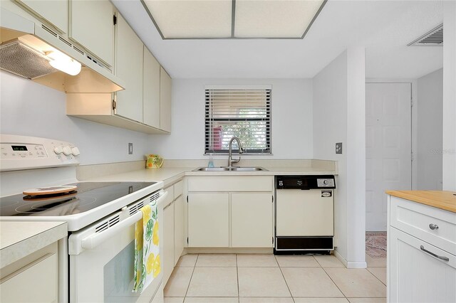 kitchen with light tile patterned floors, visible vents, a sink, white appliances, and under cabinet range hood