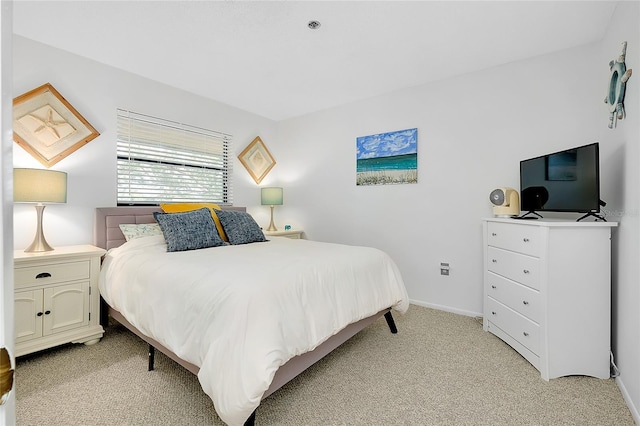 bedroom featuring baseboards and light colored carpet