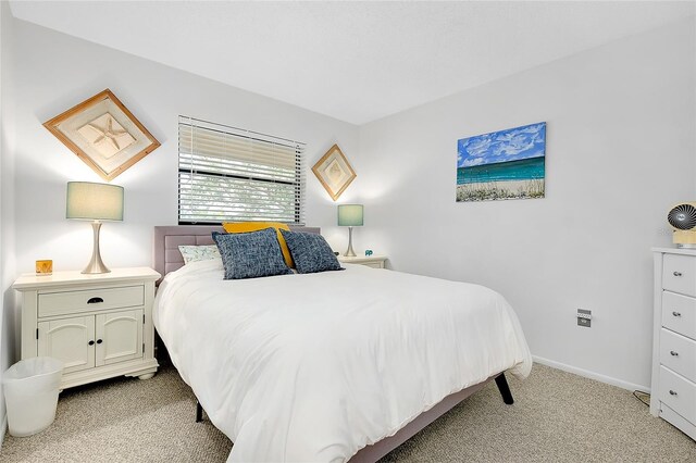 bedroom with baseboards and light colored carpet