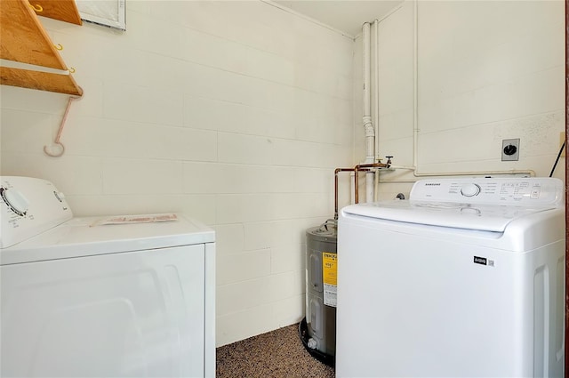 clothes washing area with concrete block wall, laundry area, and washer and clothes dryer