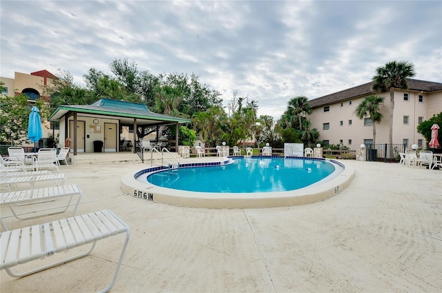 community pool featuring a patio and fence