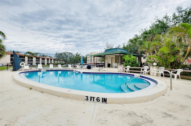 community pool featuring a patio area and fence