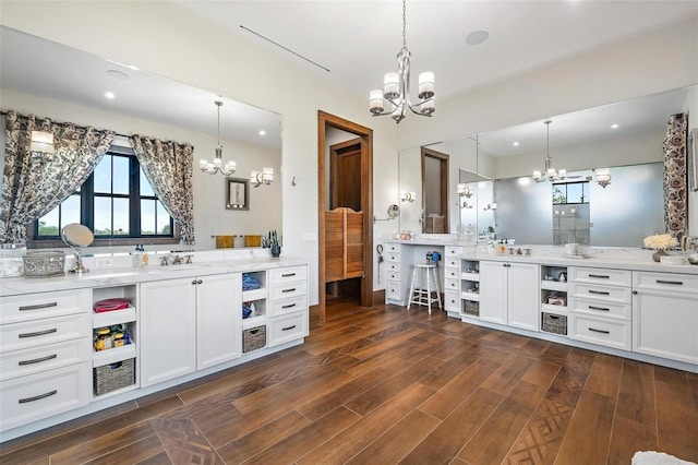 interior space featuring dark wood finished floors, pendant lighting, a notable chandelier, and recessed lighting