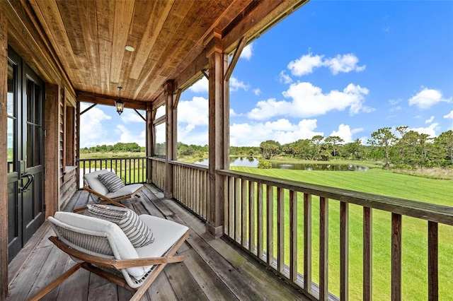 deck featuring a water view and a lawn