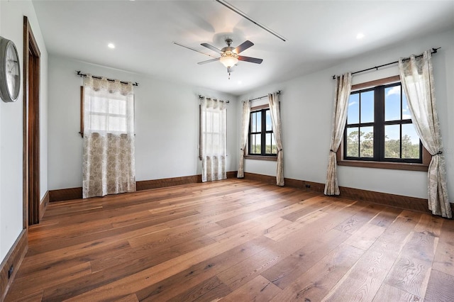 unfurnished room with recessed lighting, wood-type flooring, a ceiling fan, and baseboards