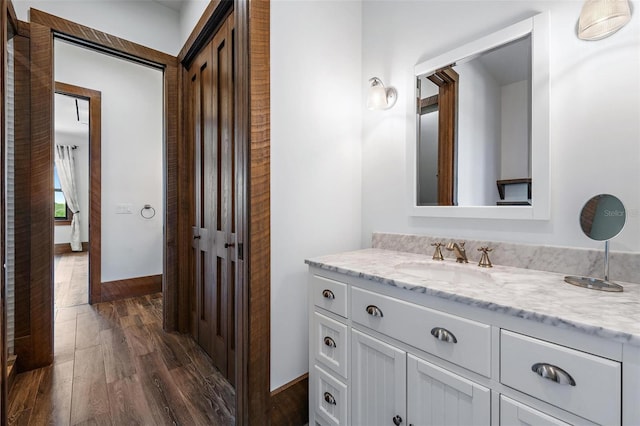 bathroom featuring baseboards, wood finished floors, and vanity