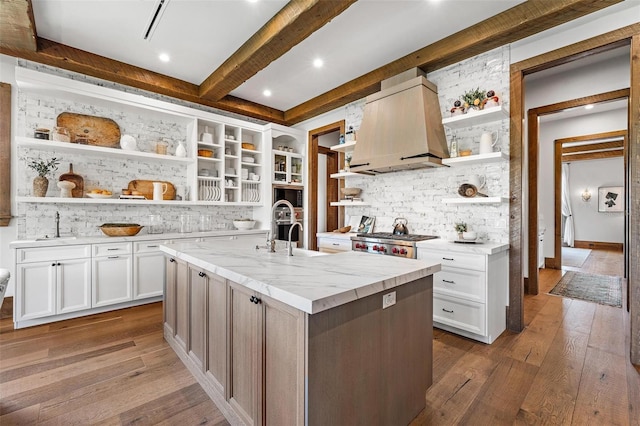 kitchen featuring premium range hood, a sink, range, open shelves, and wood-type flooring