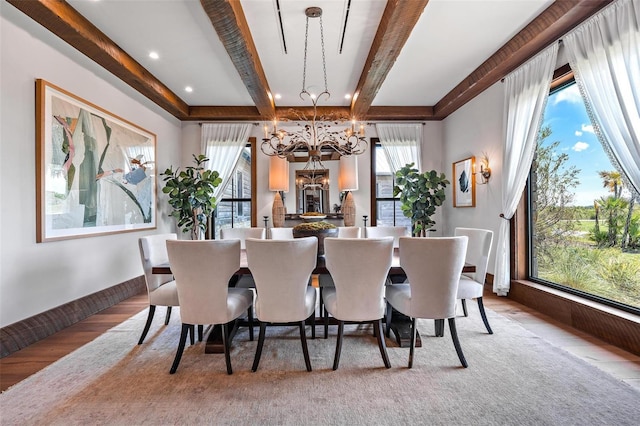 dining room featuring wood finished floors, beamed ceiling, and an inviting chandelier