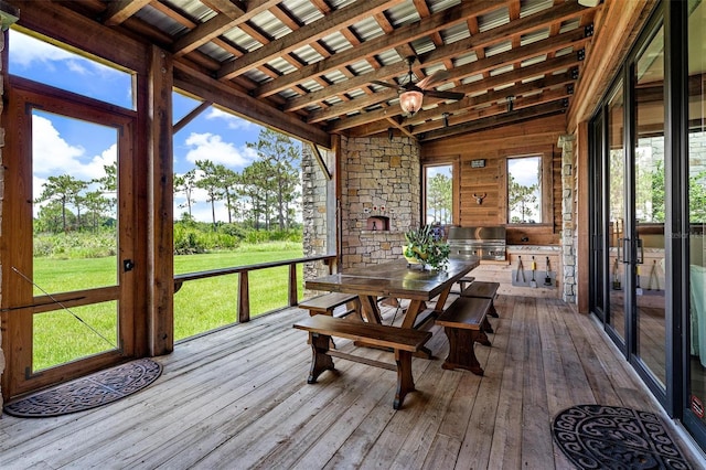 sunroom / solarium featuring a ceiling fan and beamed ceiling