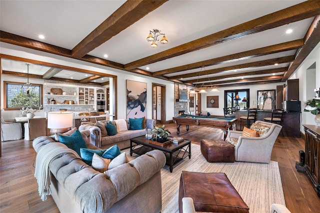 living room featuring hardwood / wood-style flooring, a fireplace, beam ceiling, and pool table