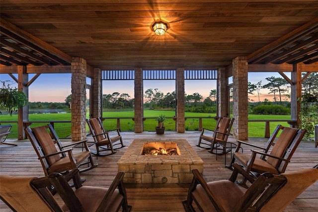 patio terrace at dusk with a lawn and a fire pit