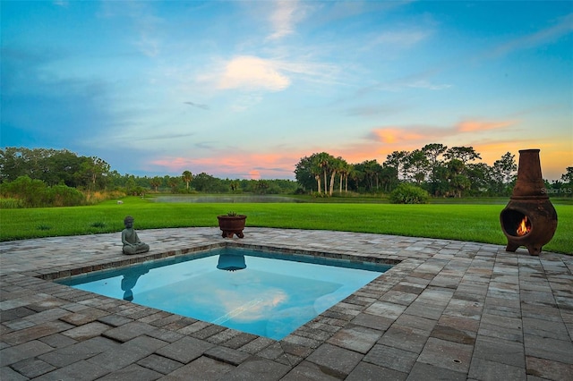 view of pool with a patio and a lawn