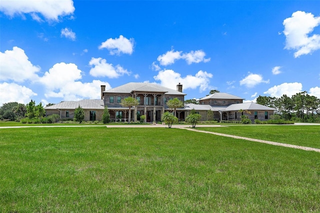 view of front facade with a chimney and a front lawn