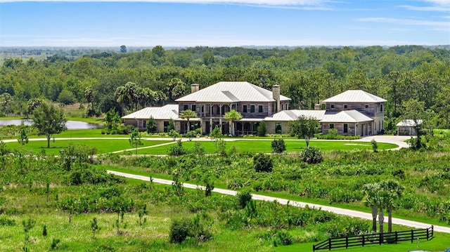 view of community with a lawn, fence, and a wooded view